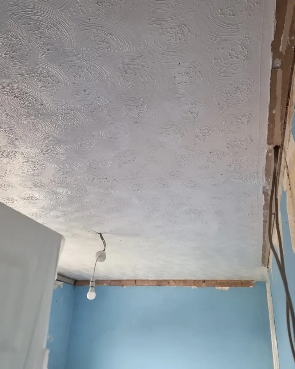 Swirled Artex ceiling in a Woodford bedroom before skimming
