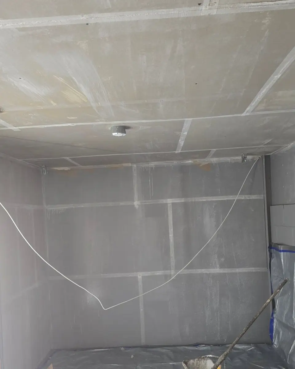 Walls and ceiling in plasterboard with taped joints, ready to skim
