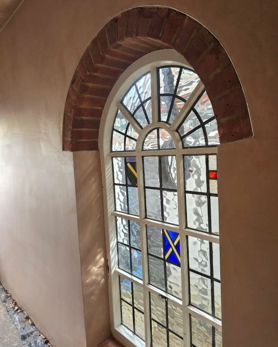 Walls plastered round an arched leaded window — ST Plastering & Rendering