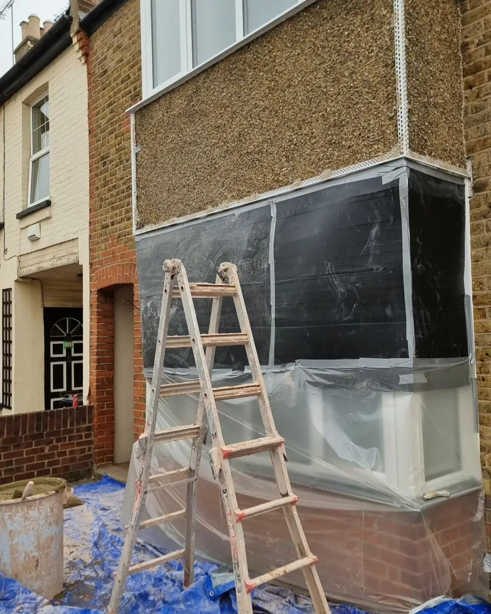 Terraced house bay before rendering, old pebbledash above and membrane below