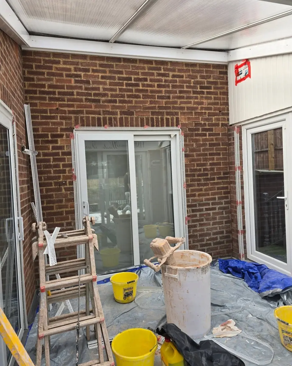 Conservatory in Epping with bare brick walls and new render beads, before rendering